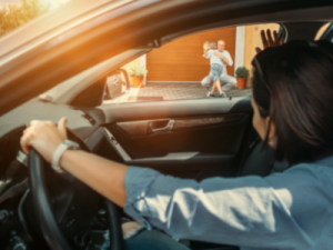 joint shared custody - image of mother driving a car, waving to the father who is greeting the son with a hug - call HCM Legal today