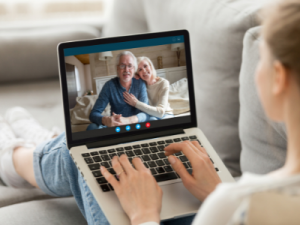 immigration sponsor parents - image of young girl on the couch video calling grandparents on a laptop - call HCM Legal today