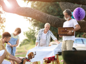 relative sponsored visa - image of child, parent and grandparents setting up a picnic table in the sunshine with the family dog - call HCM Legal today