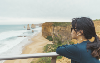 trusted visitor visa australia lawyer - image of lady looking at theTwelve Apostles coastline - call HCM Legal today
